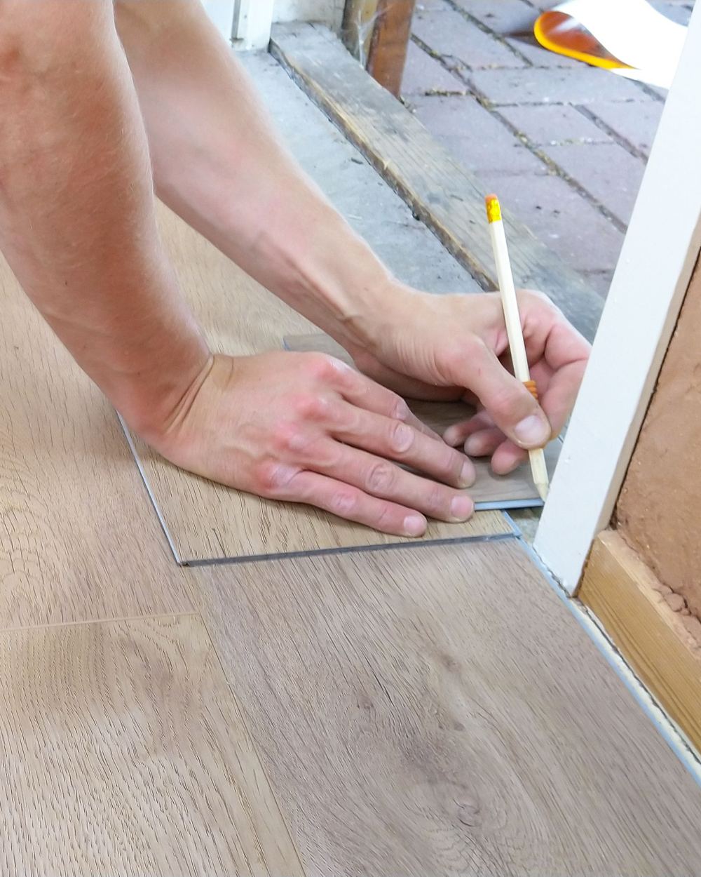 Installing plank flooring by hand, illustrative stock photo