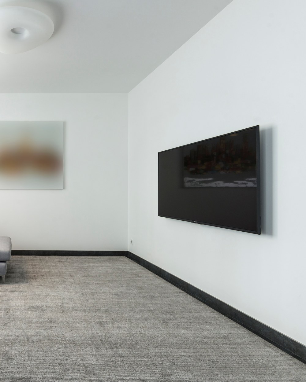 Wall-mounted TV in a finished living room, illustrative stock photo